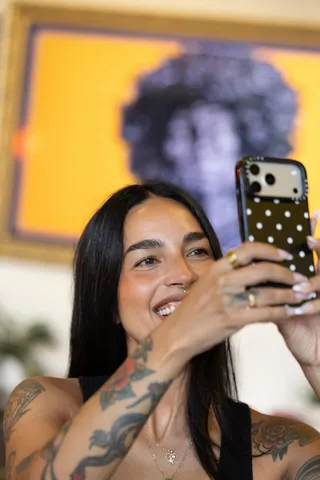 Liz shooting a wall of artwork on her phone