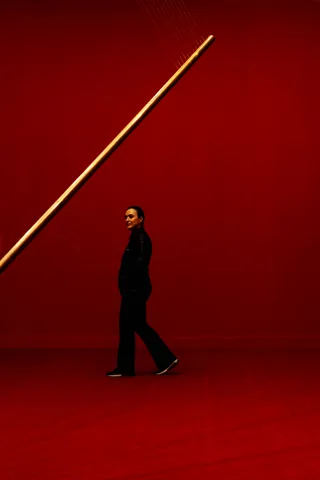 A lone figure crossing a red wall