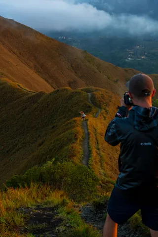 A photographer shooting from a mountain ridge