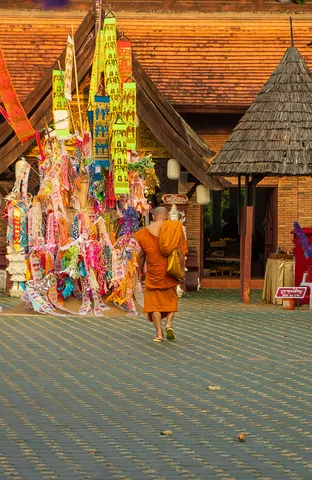 A monk passing a shrine hung with color