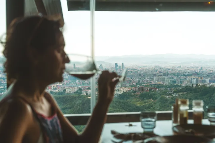 A glass of wine over the city at golden hour